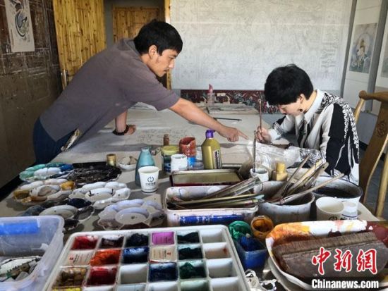 圖為2020年8月下旬，敦煌“80后”畫(huà)家張杰龍(左)在為云南麗江“學(xué)生”莫北講解敦煌壁畫(huà)的繪畫(huà)技巧。　馮志軍 攝