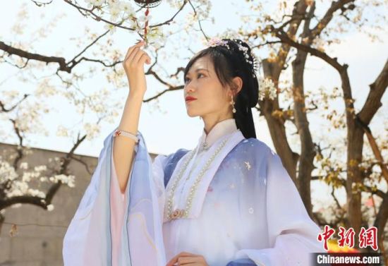 圖為蘭州青年身穿漢服在百年梨園賞景?！「哒?攝