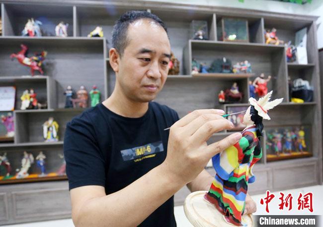 圖為安秋平正在創(chuàng)作代表隴南文縣民俗的《白馬人》作品?！「哒?攝