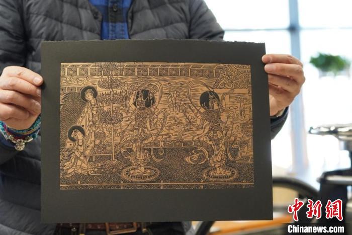 圖為手工書藝人展示敦煌雕版壁畫印刷品?！【琶赖┰?　攝