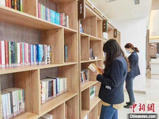 圖為在甘肅公航旅建設(shè)集團(tuán)有限公司的職工書屋，職工挑選書籍?！⌒煅?攝