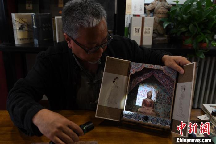 圖為讀者出版集團讀者晉林工作室獨立出品人徐晉林，展示互動性強的敦煌題材手工書。(資料圖) 楊艷敏 攝